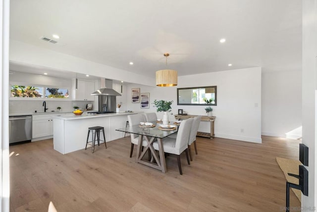 dining area with sink and light wood-type flooring