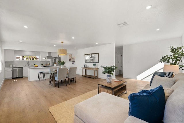 living room with sink and light hardwood / wood-style flooring