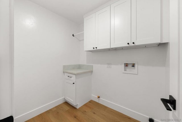 washroom featuring cabinets, washer hookup, and light wood-type flooring