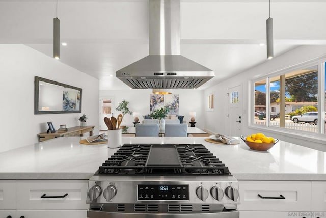 kitchen with pendant lighting, gas range, range hood, and white cabinets