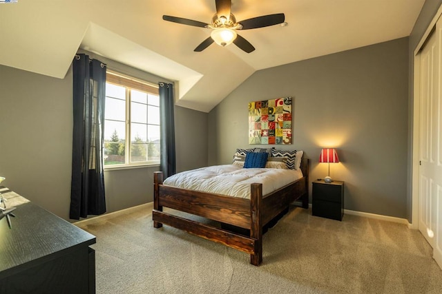 bedroom with vaulted ceiling, a closet, ceiling fan, and carpet flooring