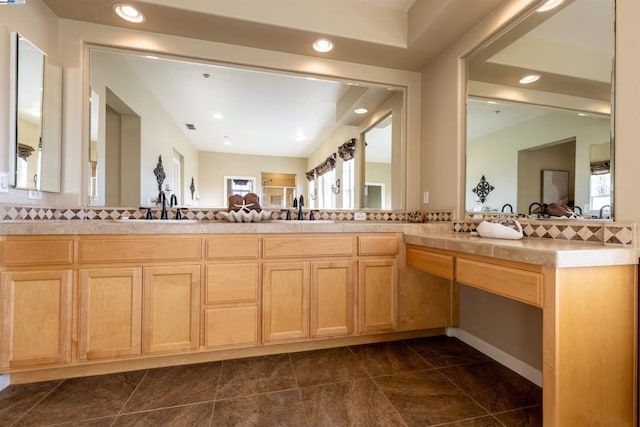 bathroom featuring tasteful backsplash, vanity, and a wealth of natural light