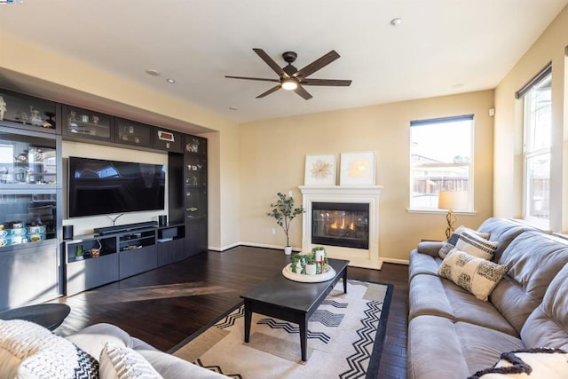 living room featuring ceiling fan and dark hardwood / wood-style flooring