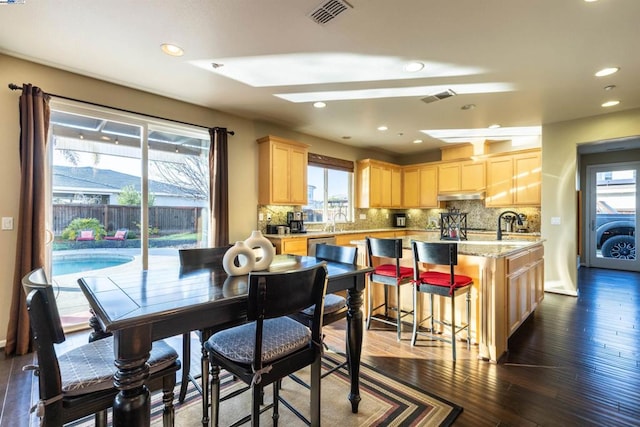 dining space with plenty of natural light, dark hardwood / wood-style flooring, and sink