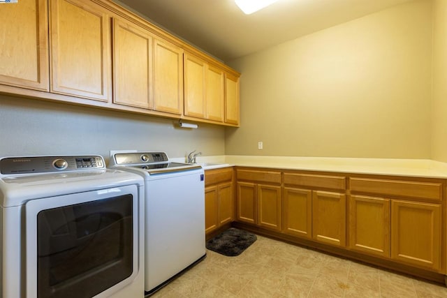 washroom with sink, cabinets, and washing machine and clothes dryer