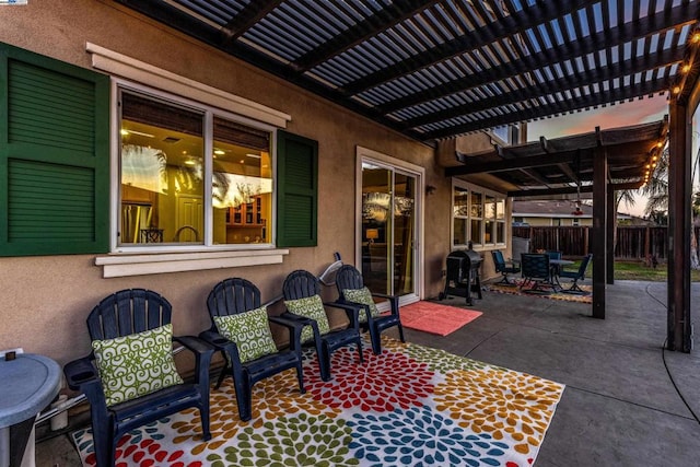 patio terrace at dusk with a pergola and grilling area