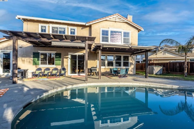 back of house with a fenced in pool and a patio area