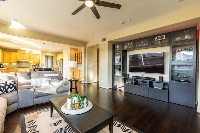 living room with ceiling fan and dark hardwood / wood-style floors