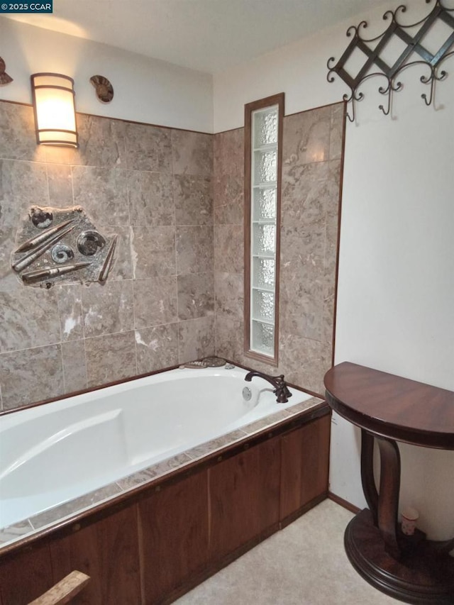 bathroom with a relaxing tiled tub and tile walls