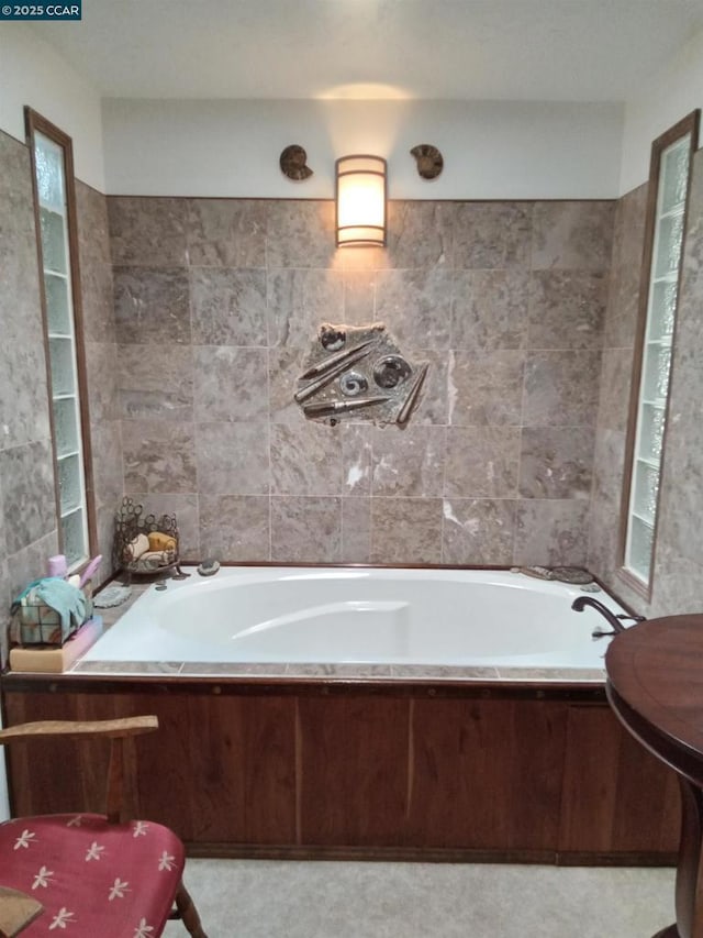 bathroom featuring tile walls and a relaxing tiled tub