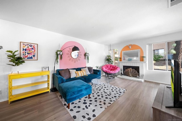 living room with a fireplace and wood-type flooring