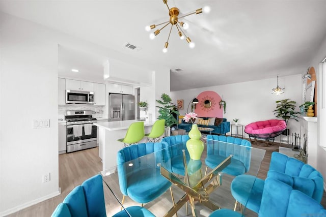 dining space featuring a notable chandelier and light hardwood / wood-style floors