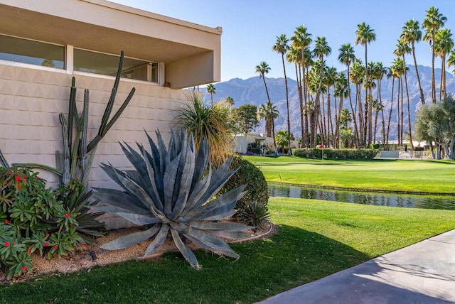 exterior space with a water and mountain view and a yard