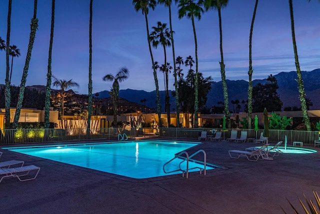 pool at dusk with a mountain view and a patio area