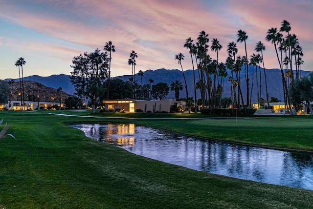 view of property's community featuring a water and mountain view and a lawn