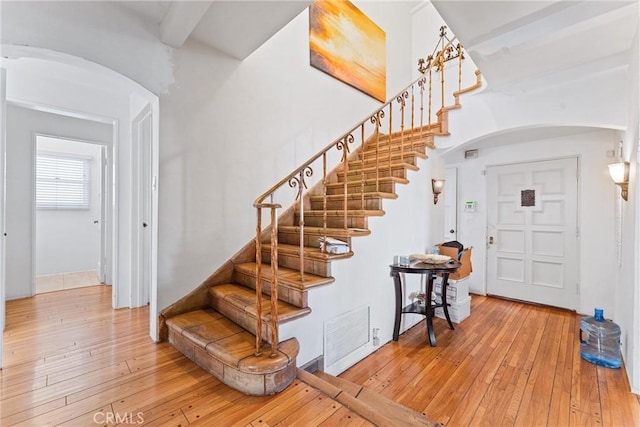 foyer entrance with beamed ceiling and light wood-type flooring