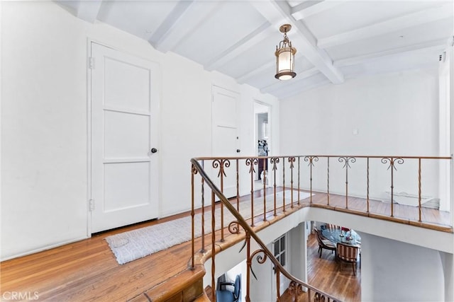 hall with hardwood / wood-style flooring and lofted ceiling with beams