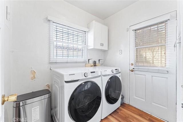 washroom featuring cabinets, independent washer and dryer, and light wood-type flooring