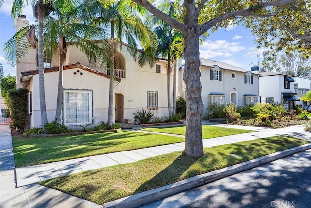 mediterranean / spanish home with a front lawn