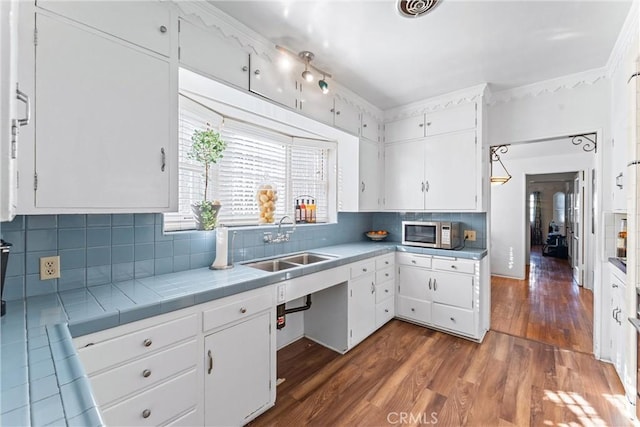 kitchen with sink, tile countertops, white cabinets, and dark hardwood / wood-style flooring