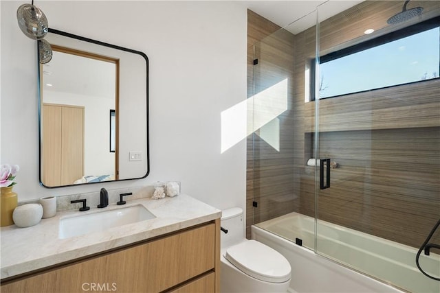 full bathroom with vanity, shower / bath combination with glass door, and toilet