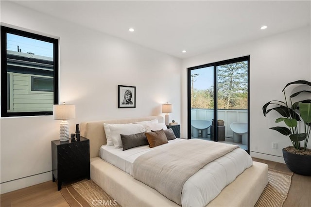 bedroom with access to exterior and light hardwood / wood-style floors