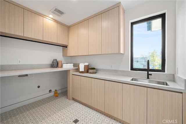 kitchen with light brown cabinetry and sink