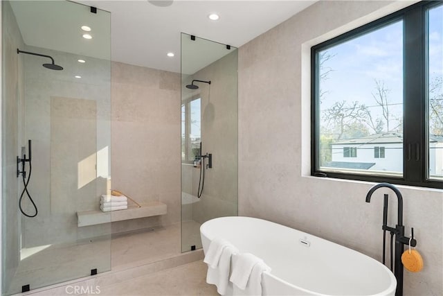 bathroom with shower with separate bathtub and plenty of natural light