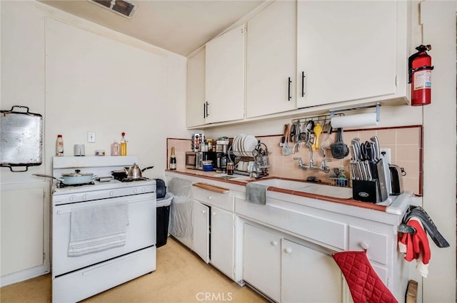 kitchen with white cabinetry, sink, white range with gas stovetop, and decorative backsplash