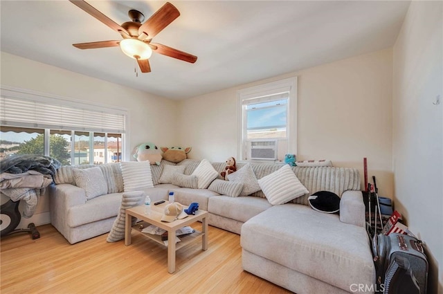 living room with cooling unit, ceiling fan, and light wood-type flooring