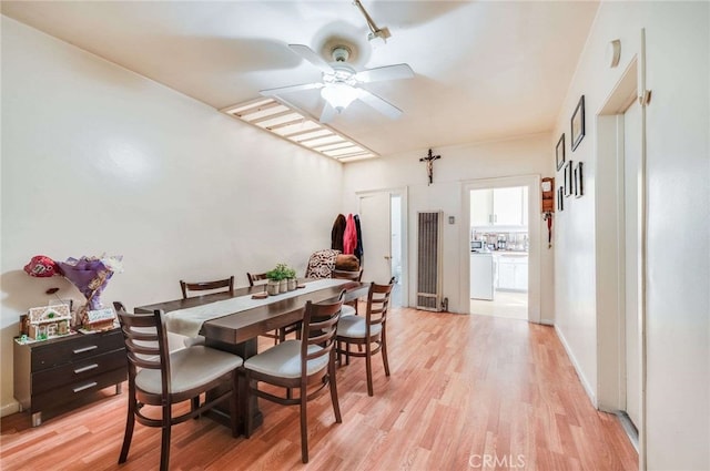 dining room with washer / dryer, ceiling fan, and light wood-type flooring