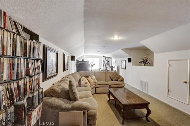 living room featuring vaulted ceiling, light colored carpet, and a textured ceiling