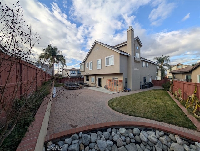 rear view of property with a lawn and a patio