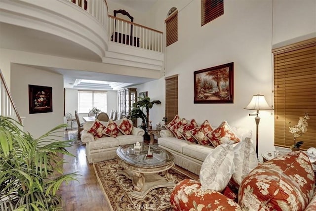 living room with wood-type flooring and a high ceiling