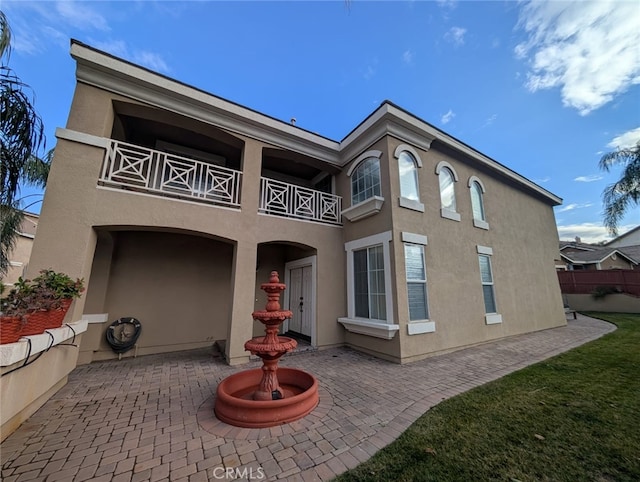 back of property featuring a patio area and a balcony