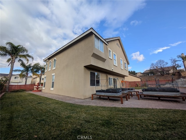 rear view of property featuring a patio area and a lawn