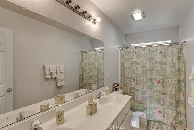 bathroom with walk in shower, vanity, and toilet