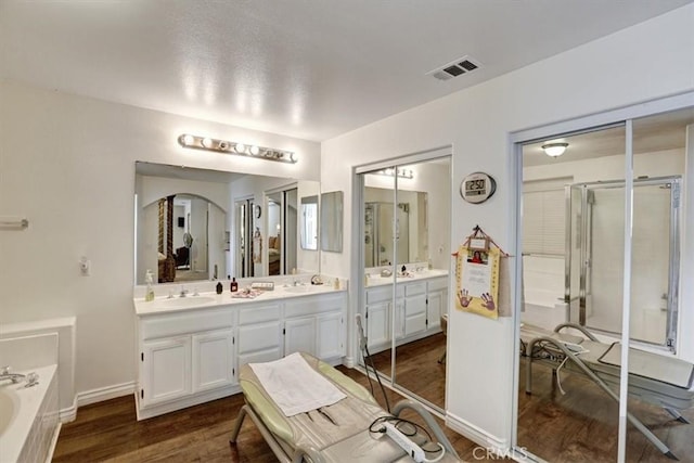 bathroom featuring wood-type flooring, independent shower and bath, and vanity