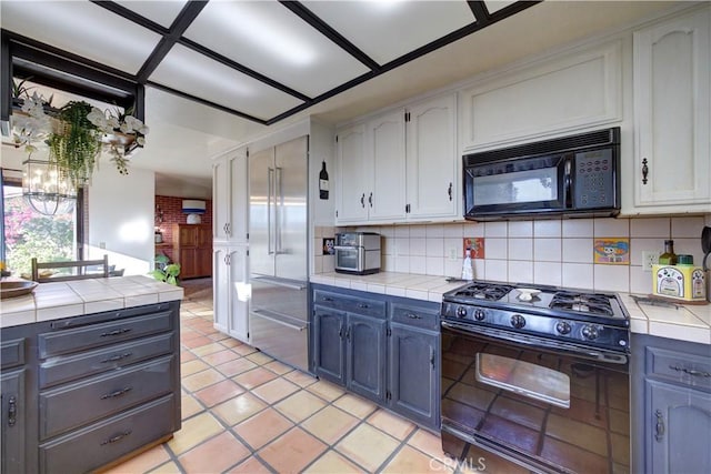 kitchen with decorative backsplash, tile countertops, black appliances, and white cabinets