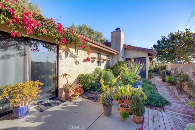 exterior space featuring a wooden deck and a patio