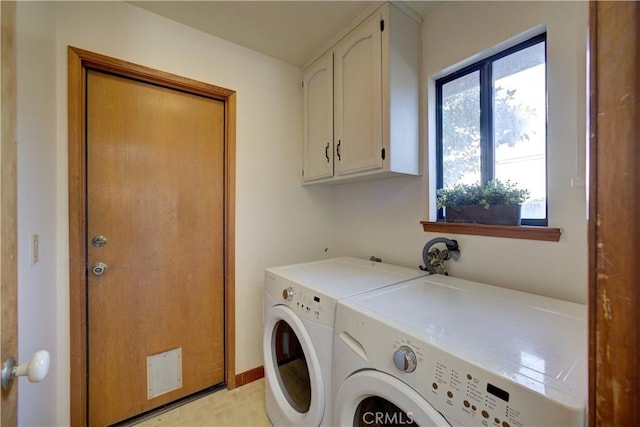 clothes washing area featuring cabinets and washing machine and dryer