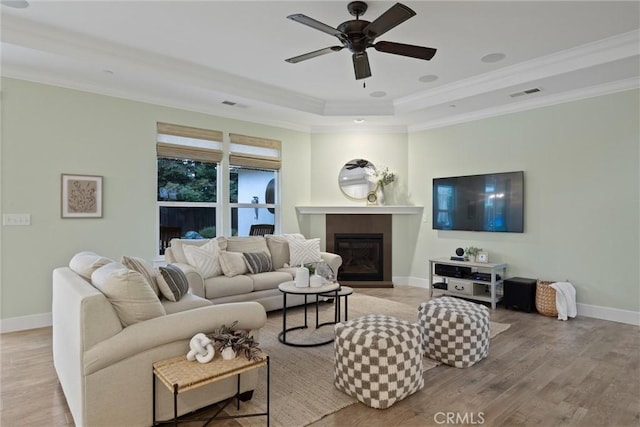 living room with crown molding, ceiling fan, and light hardwood / wood-style flooring