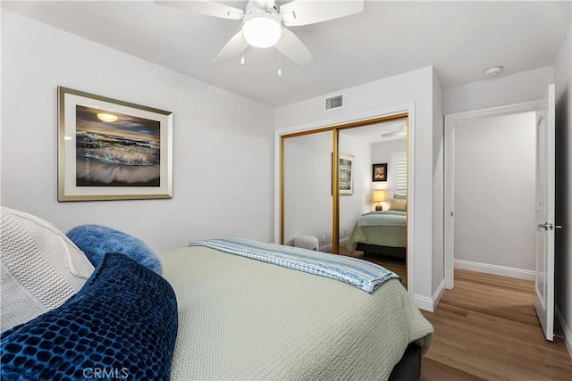 bedroom with ceiling fan, hardwood / wood-style floors, and a closet