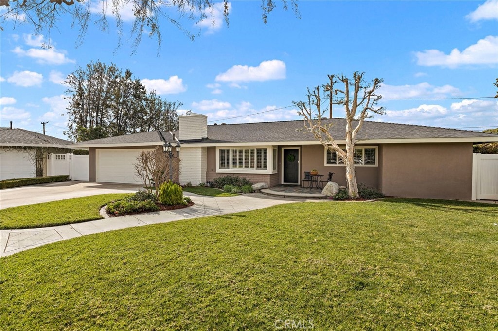 ranch-style home with a garage and a front lawn