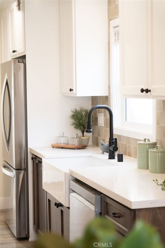 kitchen featuring white cabinetry, appliances with stainless steel finishes, and decorative backsplash