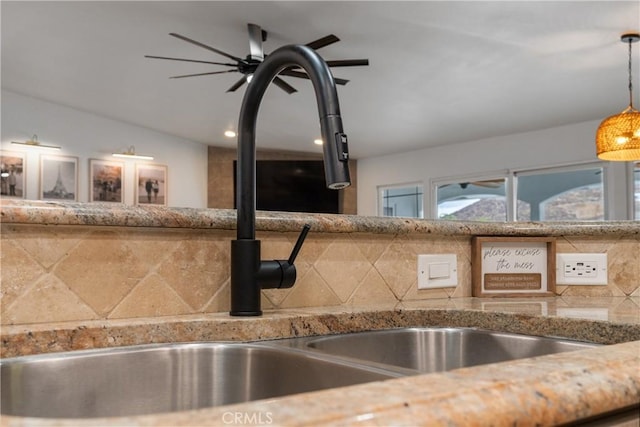 room details with sink, backsplash, ceiling fan, and decorative light fixtures