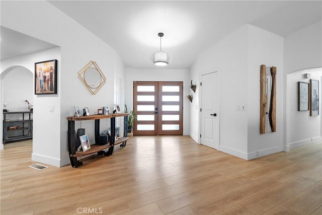 entryway with french doors and light hardwood / wood-style floors