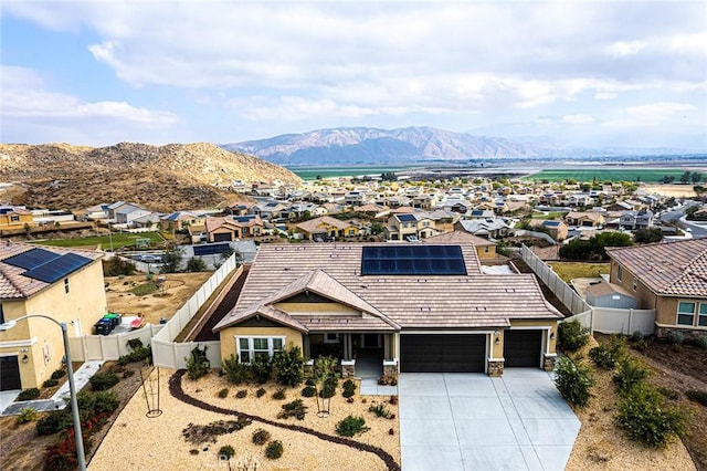 view of front facade featuring a garage, a mountain view, and solar panels