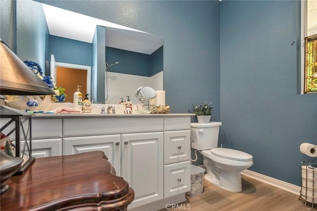 bathroom featuring vanity, hardwood / wood-style flooring, and toilet