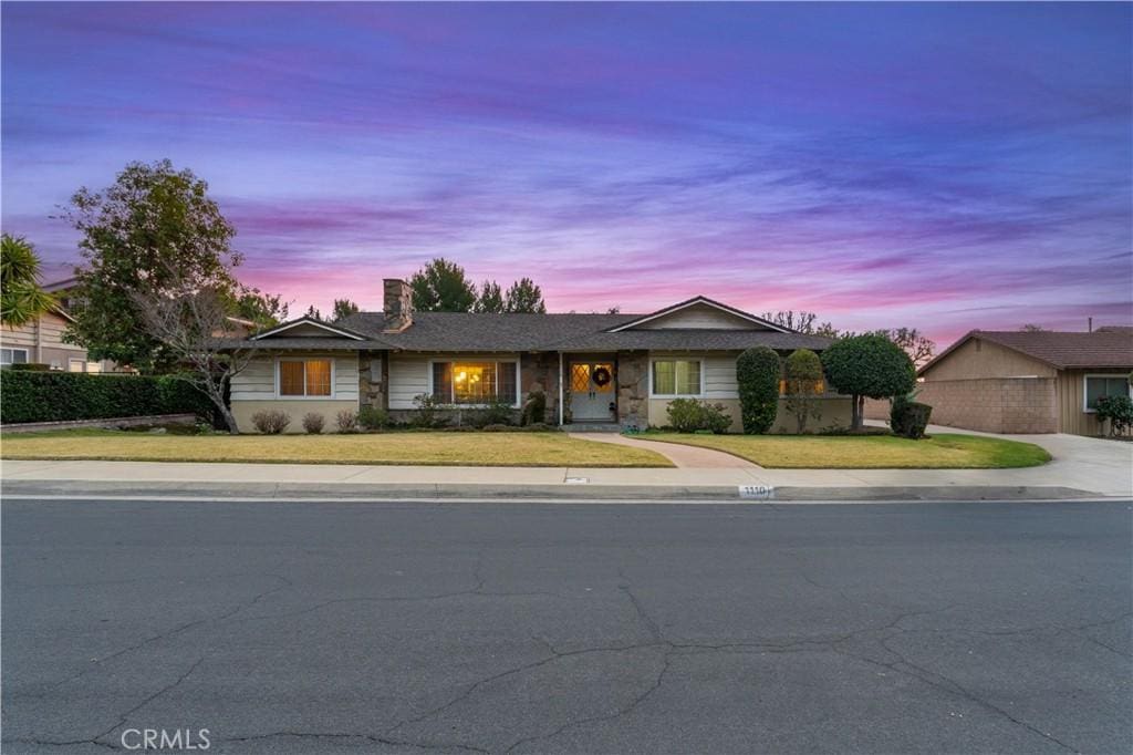 single story home with a lawn